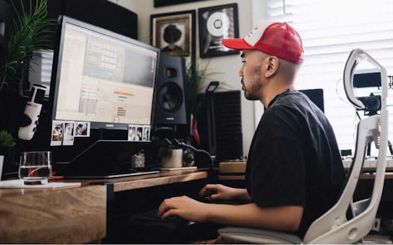 Chris Ju, a musician, producing songs on his computer